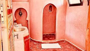 A bathroom with a curved design, a sink, and a mirror.
