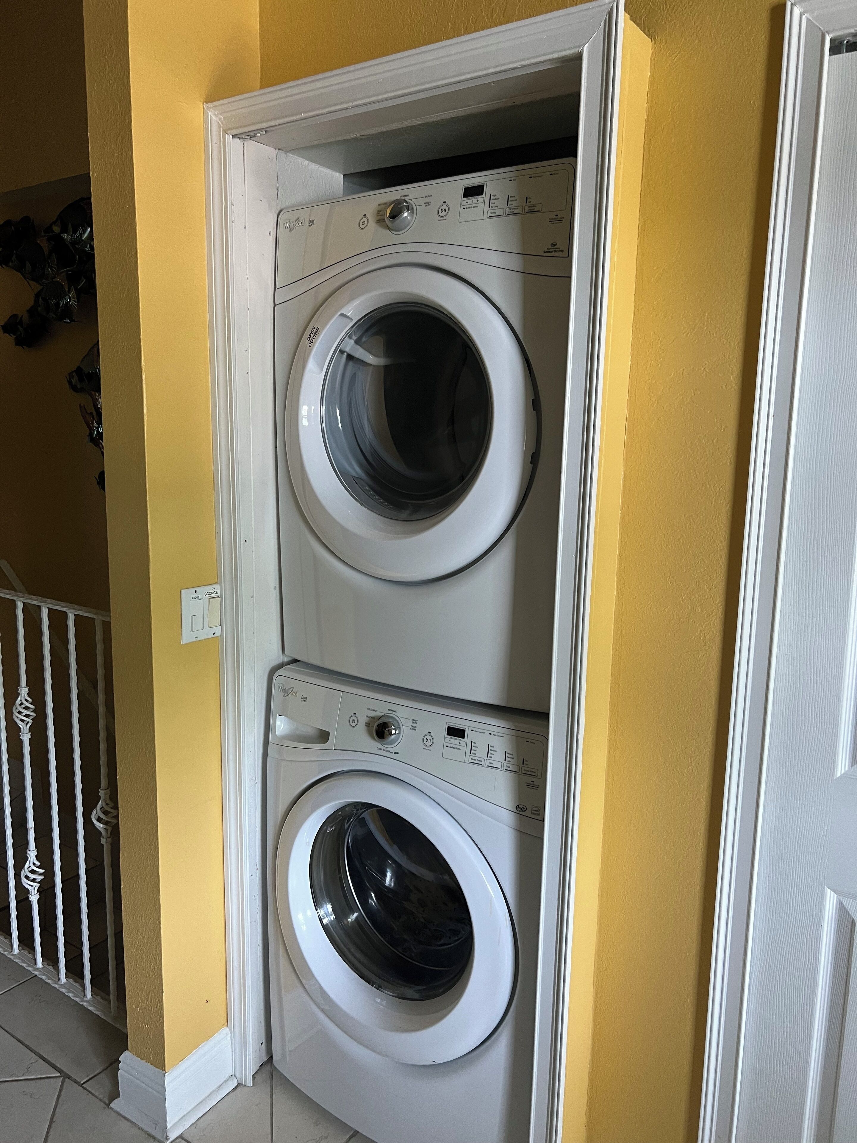 Una sala de lavandería con dos lavadoras apiladas.
