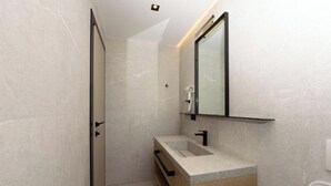 A modern bathroom with a walk-in shower, a wooden vanity, and a mirror above the sink. - Perla Del Sol (Vlorë)