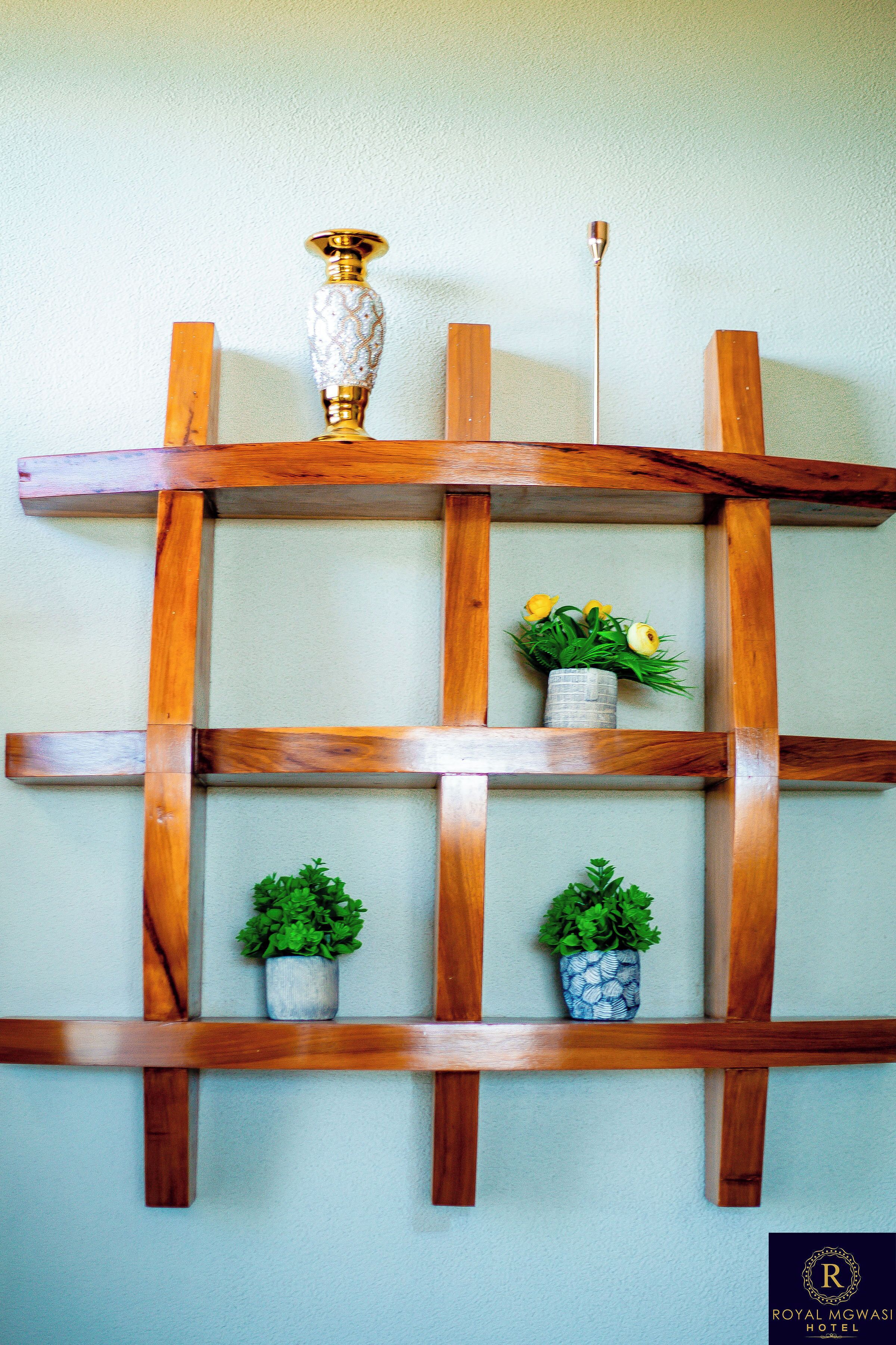 Una estantería de madera con jarrones decorativos y plantas en macetas.