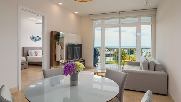 Una sala moderna con una mesa de comedor de vidrio, un sofá y un televisor.