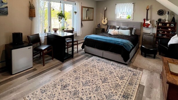 A bedroom with a bed, a desk, a chair, a coffee maker, a guitar, and a clock on the wall. - In home mini wing private space. 💜Stay at Hal's Salem, MA (Salem)