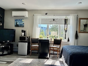 A room with a bed, a desk with a chair, a television, a refrigerator, and a window with curtains. - In home mini wing private space. 💜Stay at Hal's Salem, MA (Salem)
