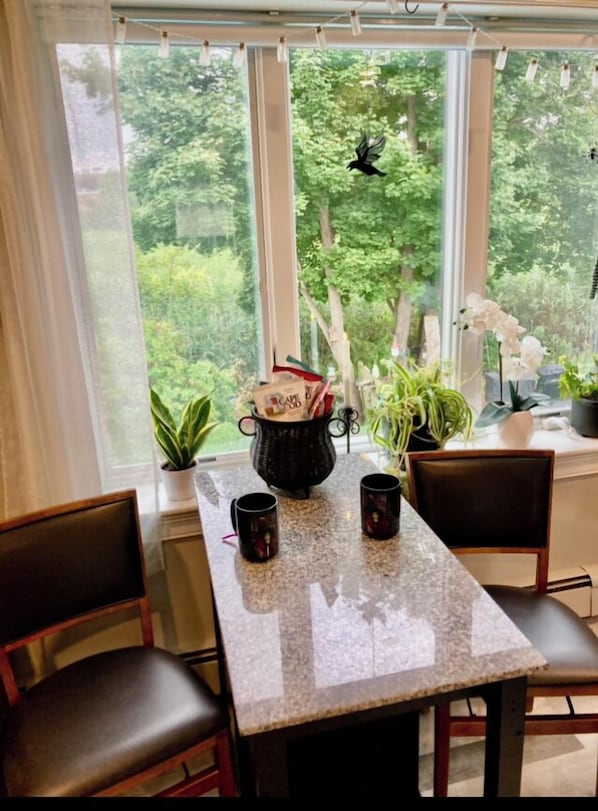 A dining area with a table, chairs, and potted plants. - In home mini wing private space. 💜Stay at Hal's Salem, MA (Salem)
