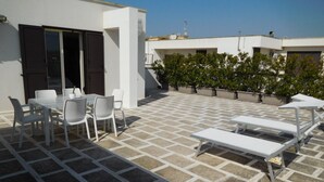 A rooftop terrace with a table and chairs, a sun lounger, and potted plants. - Loft San Giovanni In Gallipoli (Gallipoli)