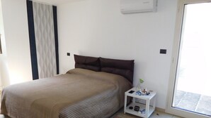A bedroom with a bed, a bedside table with a lamp, and a window. - Loft San Giovanni In Gallipoli (Gallipoli)