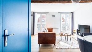 Un salon moderne avec un canapé marron, une table basse et un téléviseur.