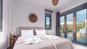 Ein modernes Hotelzimmer mit einem großen Bett, einem Wandkunstwerk und einem Balkon mit Aussicht.