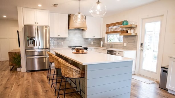 A modern kitchen with a central island, stainless steel appliances, and a large window. - Crabby Coconut-Mid-Island 3BR Perfect for Families! Sleeps 8 (Fort Myers Beach)