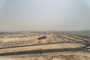 A desert landscape with a large building labeled "DAMAC" and multiple highways.