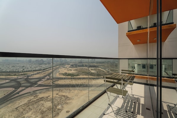 A high-rise building with a view of a cityscape and a desert area.