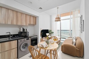 Departamento Deluxe, balcón | Cocina privada | Refrigerador, microondas, horno y parrilla de estufa 