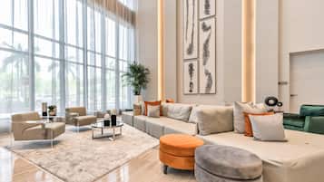 A modern living room with a large sectional sofa, a coffee table, and a potted plant.