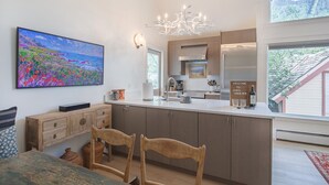 A modern kitchen with wooden cabinets, a white countertop, and a large window. - Downtown Dahl Haus: 2 bed/2 bath (Telluride)