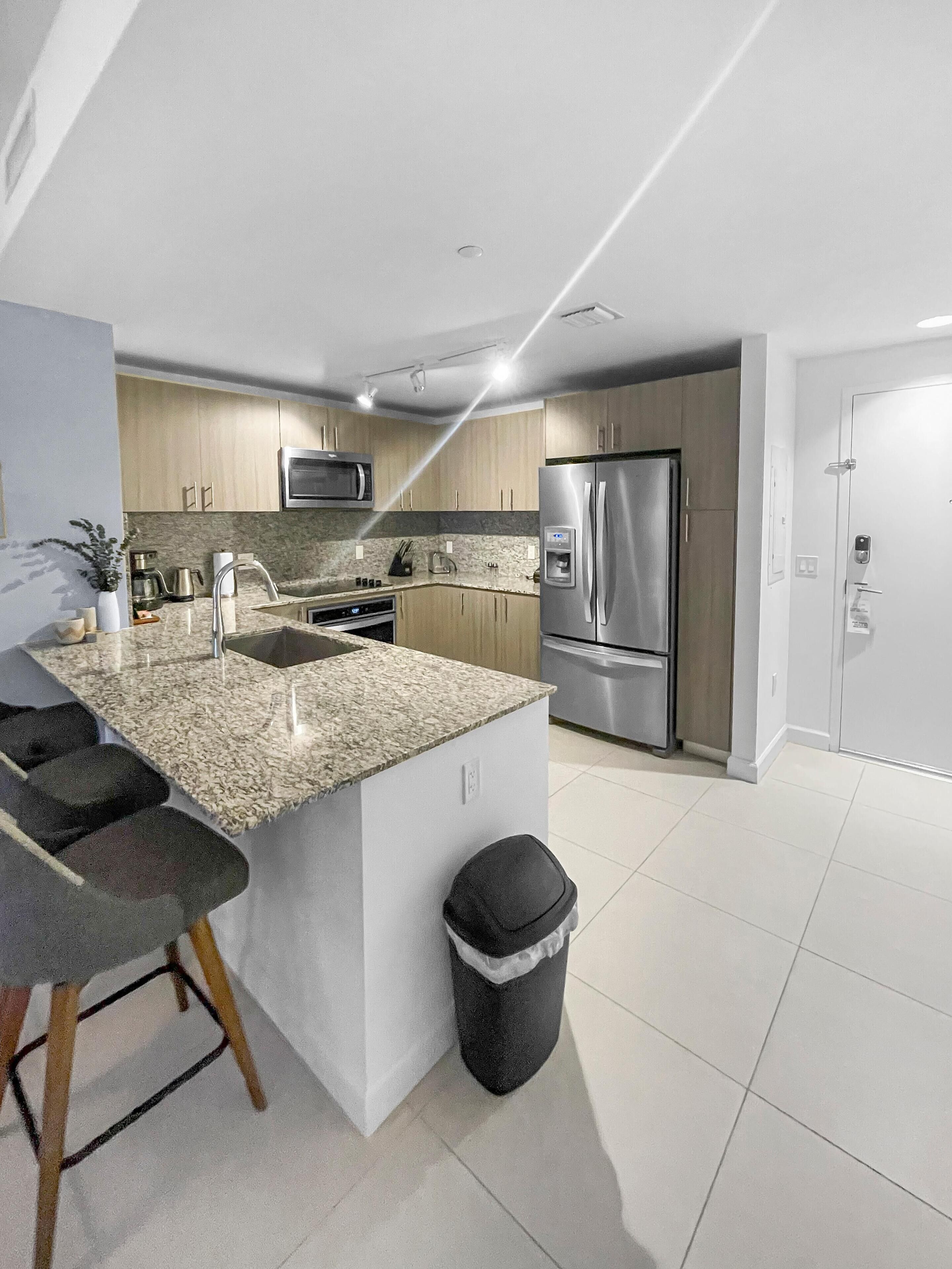 A modern kitchen with granite countertops, stainless steel appliances, and wooden cabinets.