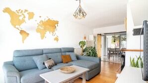 Un salon moderne avec un canapé bleu, une table basse blanche et une carte du monde accrochée au mur.