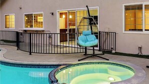 A residential property with a swimming pool, a hanging chair, and a covered patio area. - Fun-Filled Family Vacay Home! 15 min to Disney! (Fullerton)