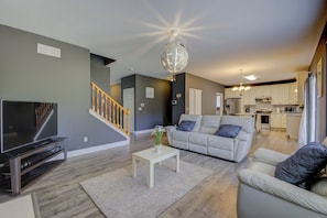A modern living room with a flat-screen TV, a white coffee table, and a grey sofa. - Beautiful 4-bedroom house Central to St. Louis and St. Charles (St. Louis)