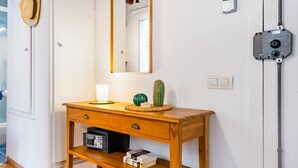 A wooden console table with a mirror, a cactus, and a radio. - BARCELONETA BEACH STUDIO 11 (Barcelona)