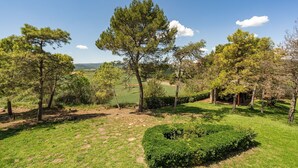 A landscape with a variety of trees and a well-maintained grassy area. - Lodging Apartments Villa el Racó (Santpedor)