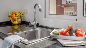 A kitchen with a stainless steel sink, a bowl of fruits, and a bowl of vegetables. - BARCELONETA BEACH STUDIO 42 (Barcelona)