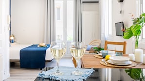 A dining table with two wine glasses, a candle, and a plant.