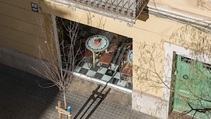 A building with a balcony, a checkered floor, and a green door.