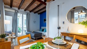 A modern hotel room with a bed, a dining area with a table set for two, a large mirror, and a view of the outside balcony. - BARCELONETA BEACH STUDIO 22 (Barcelona)