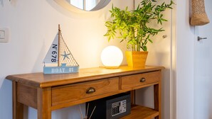 A wooden console table with a model sailboat, a potted plant, and a wall-mounted light fixture. - BARCELONETA BEACH STUDIO 22 (Barcelona)