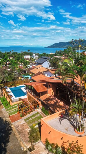 Zona residencial con piscina, casas adosadas y vista al mar.