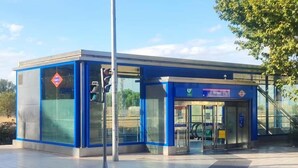 Een modern gebouw met een blauwe gevel, een glazen ingang en een bord waarop staat dat het een metrostation is.