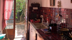 Una cocina con salpicadero de azulejos, un lavabo y una lámpara colgante.