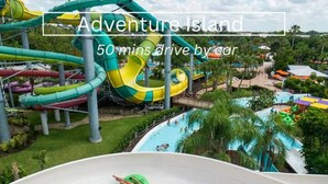 A water park with multiple slides and pools, surrounded by greenery.
