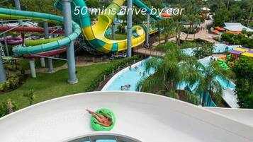 A water park with multiple slides and pools, surrounded by greenery.
