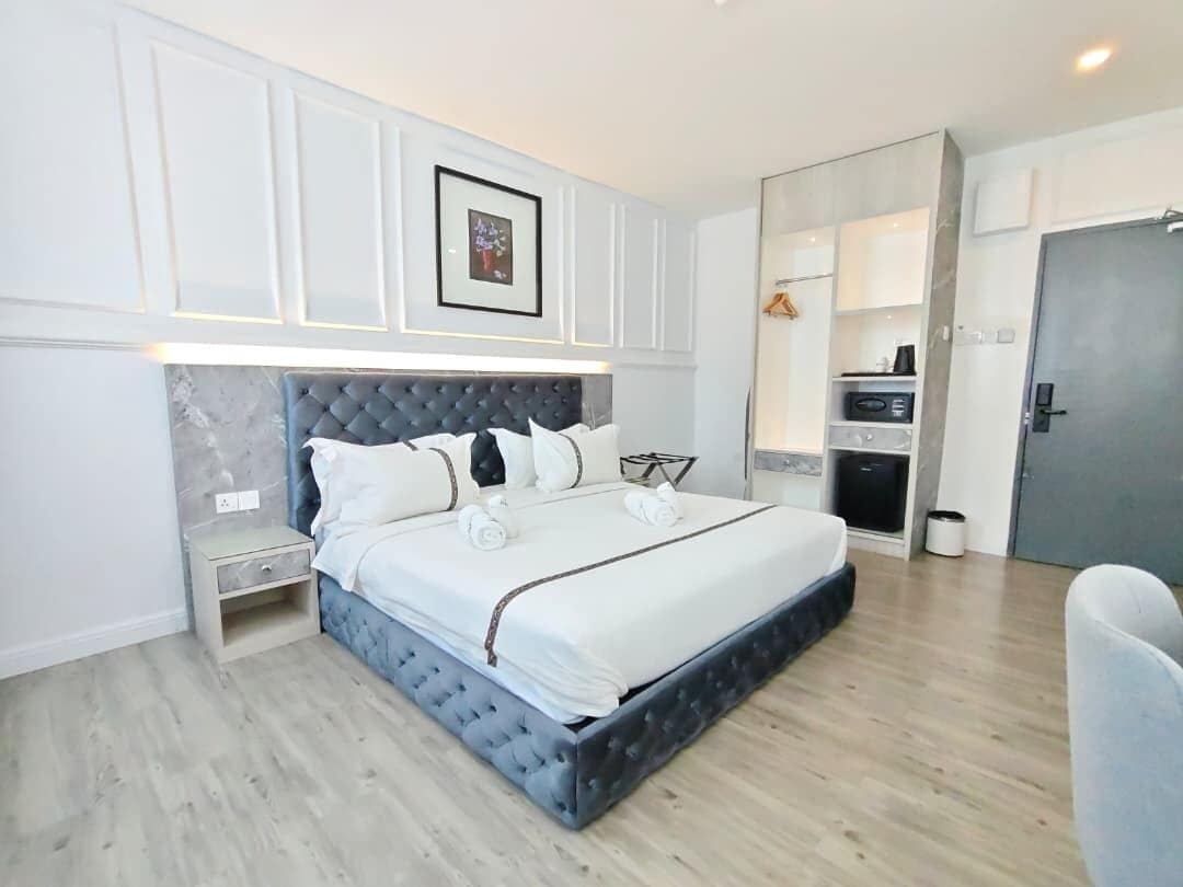 A modern bedroom with a large bed, bedside tables, a wardrobe, and a built-in desk.