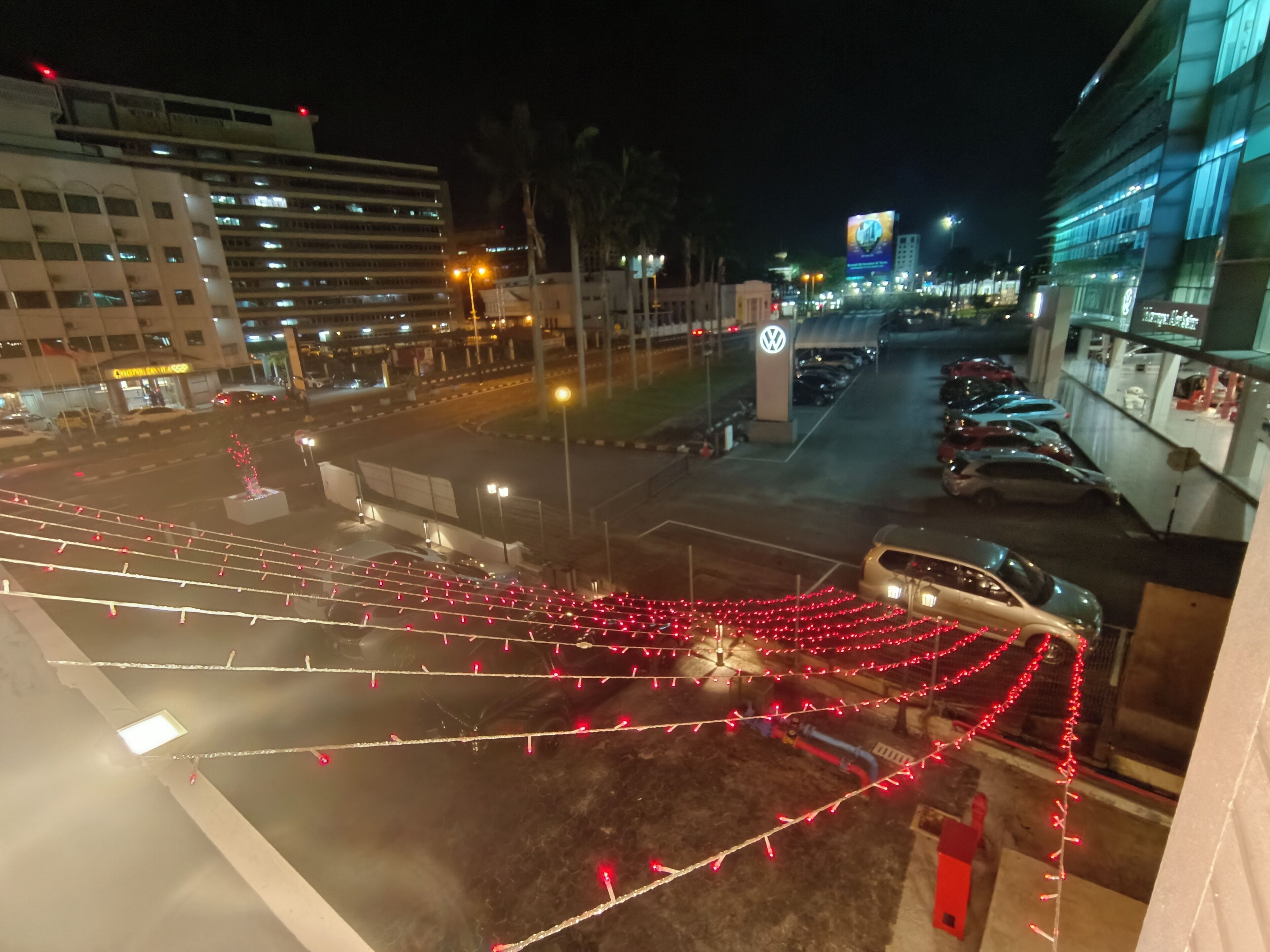 Een parkeerplaats met auto's en een gebouw op de achtergrond.