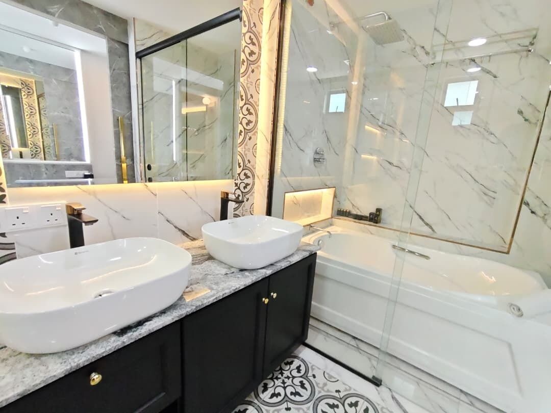 Een moderne badkamer met twee wasbakken, een bad en een grote spiegel.