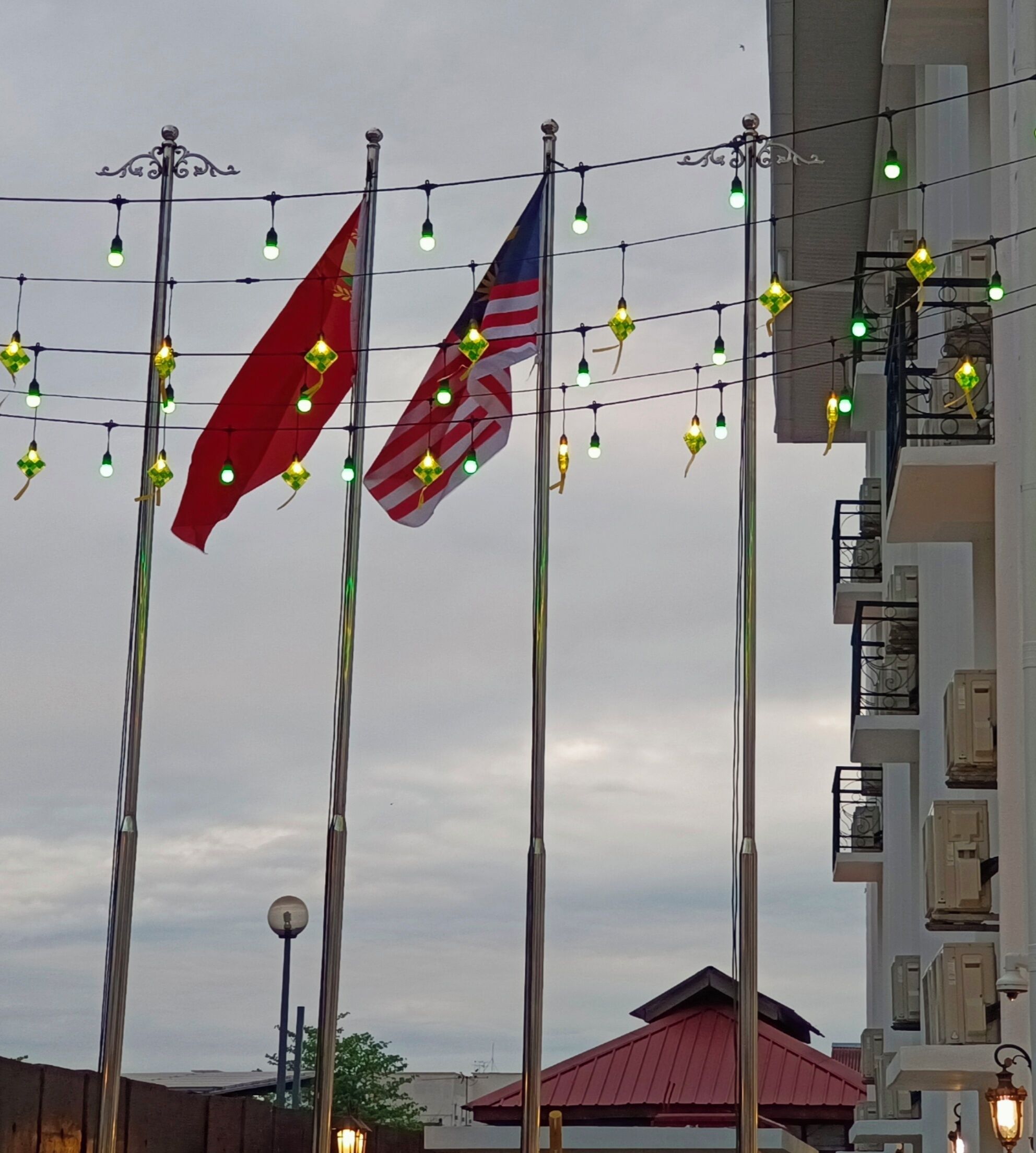 A building with multiple flags and string lights.