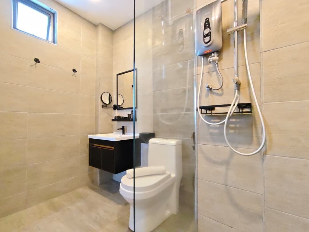 A modern bathroom with a glass-enclosed shower, a toilet, and a vanity with a mirror.