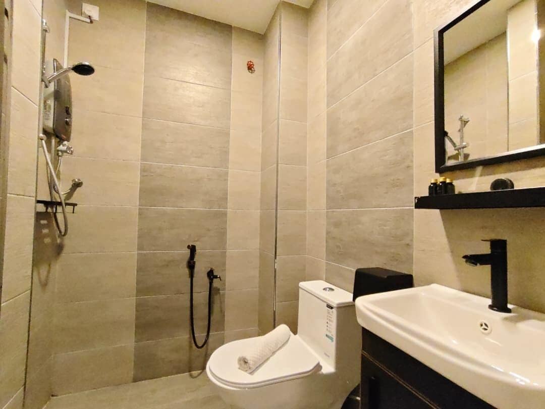A bathroom with a shower, toilet, and sink.