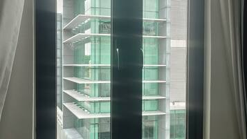 Una ventana con vista a un edificio de varios pisos y diseño moderno.