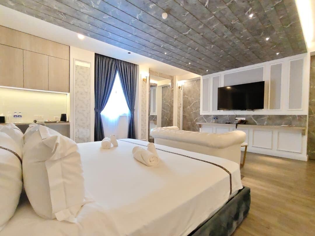 Ett hotellrum med en stor säng, en platt-TV och en sittgrupp.