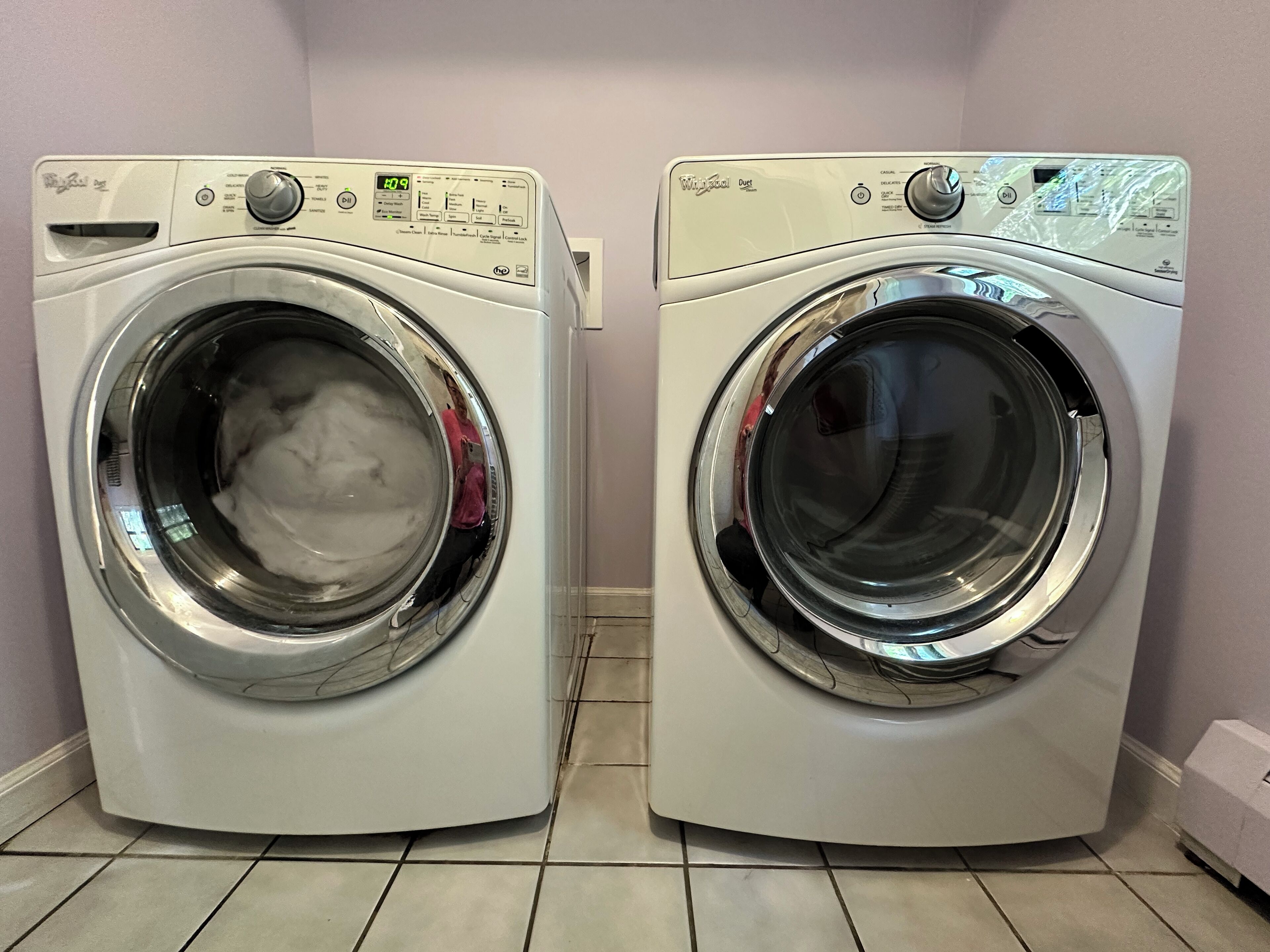 Two front-loading washing machines in a laundry room with tiled flooring.