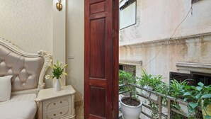 A room with a bed, nightstand, and a potted plant. - Hanoi Family Homestay (Hanoi)