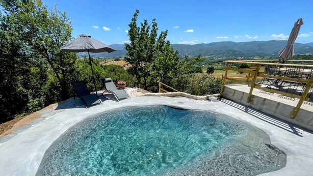 A hot tub surrounded by a deck with lounge chairs, a wooden pergola, and a view of the countryside. - Villa Ipnotica - Panoramic Views Plus Exquisite Pool - Sleeps 7 - Very Stylish (Spoleto)