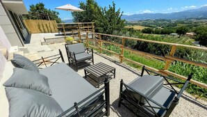 A terrace with outdoor furniture, a wooden railing, and a scenic view of the countryside. - Villa Ipnotica - Panoramic Views Plus Exquisite Pool - Sleeps 7 - Very Stylish (Spoleto)