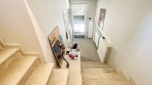 A staircase leading to a landing with a painting leaning against the wall. - Villa Ipnotica - Panoramic Views Plus Exquisite Pool - Sleeps 7 - Very Stylish (Spoleto)