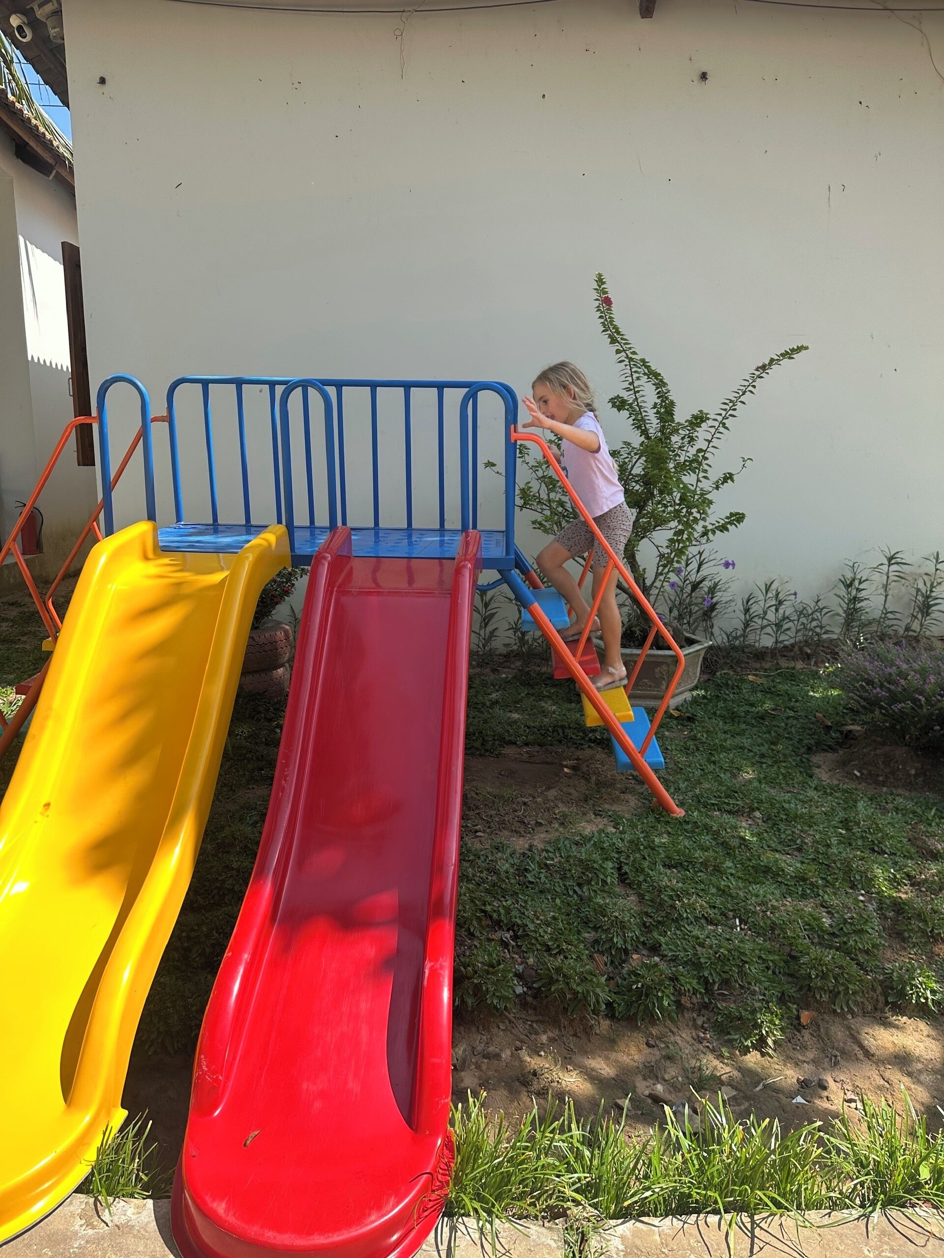 A playground with two slides and a climbing structure.
