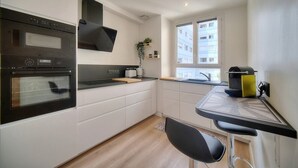 Una cocina moderna con electrodomésticos integrados, una barra y vistas a la ciudad.