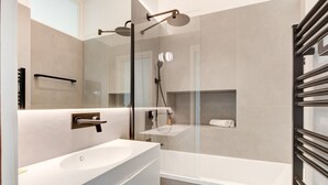 A modern bathroom with a large white sink, a glass-enclosed shower, and a towel rack. - Upstays Harbor View 83m² Apartment Palais (Cannes)
